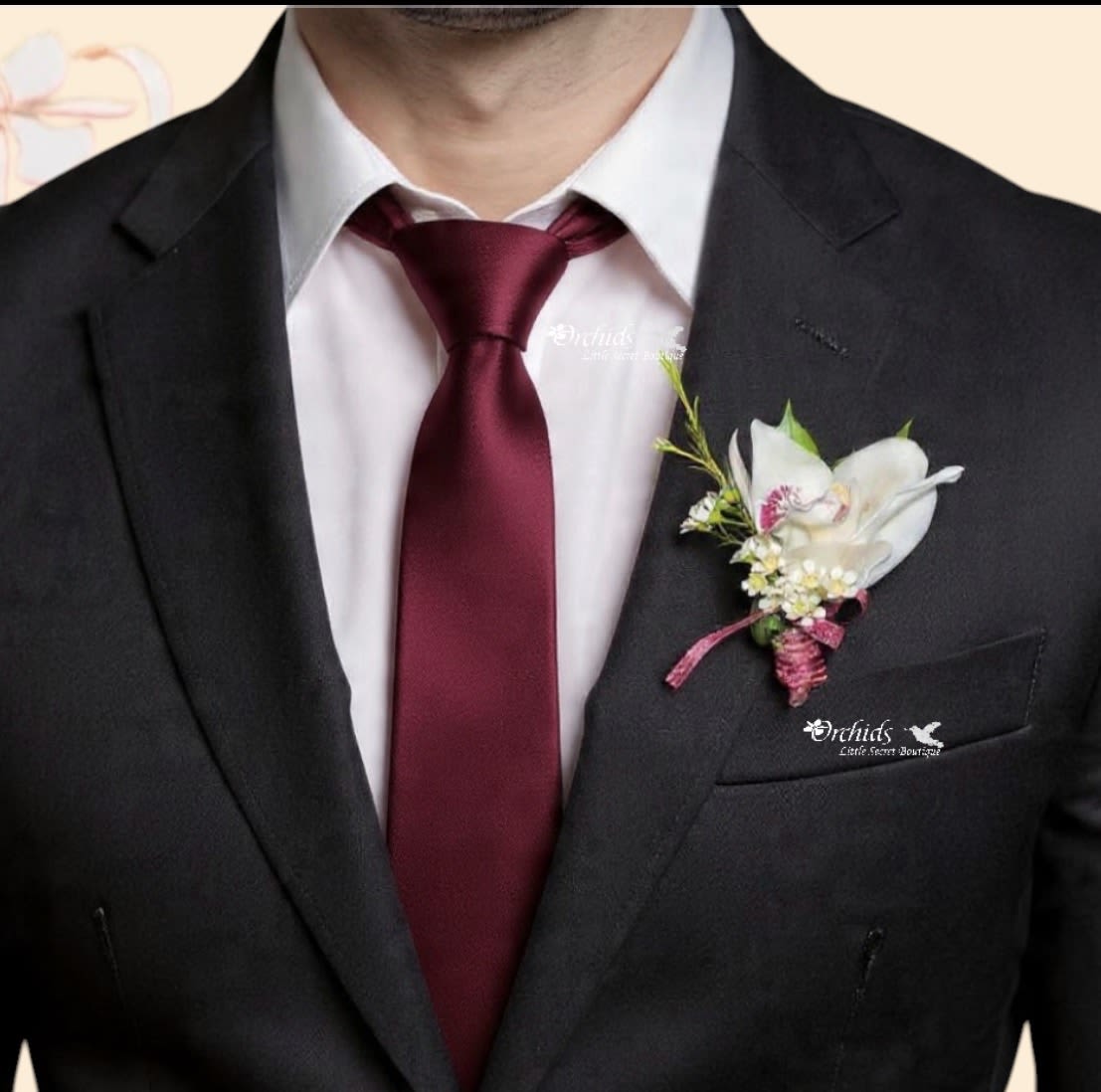 Magnetic Cymbidium Orchid Wax Flower Boutonniere  – Burgundy Wedding  - Make a lasting impression with this elegant exotic cymbidium orchid boutonniere, designed for weddings, proms, and formal events. This handcrafted piece features a fresh cymbidium orchid bloom paired with delicate wax flower accents and finished with a rich burgundy ribbon wrap for a romantic, modern look!  Unlike traditional pinned boutonnieres, this design includes a secure magnetic backing, making it easy to wear without damaging suits or delicate fabrics. It’s the perfect choice for grooms, groomsmen, prom dates, and special occasions where style and convenience matter.   Why You’ll Love It:  Fresh cymbidium orchid boutonniere (premium bloom) Accented with soft, textured wax flowers Elegant burgundy ribbon for a classic wedding look Magnetic boutonniere backing – no pins, no holes Ideal for weddings, proms, homecoming, and formal events  Perfect For:  Groom and groomsmen boutonnieres Wedding party flowers Prom and homecoming accessories Romantic or formal occasions   Safety Note: Magnets are not recommended for individuals with pacemakers or similar medical devices as they may interfere with the device's function.