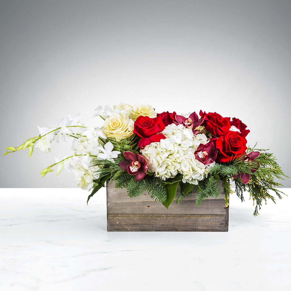 Mixed red and white flowers arranged in a wooden box