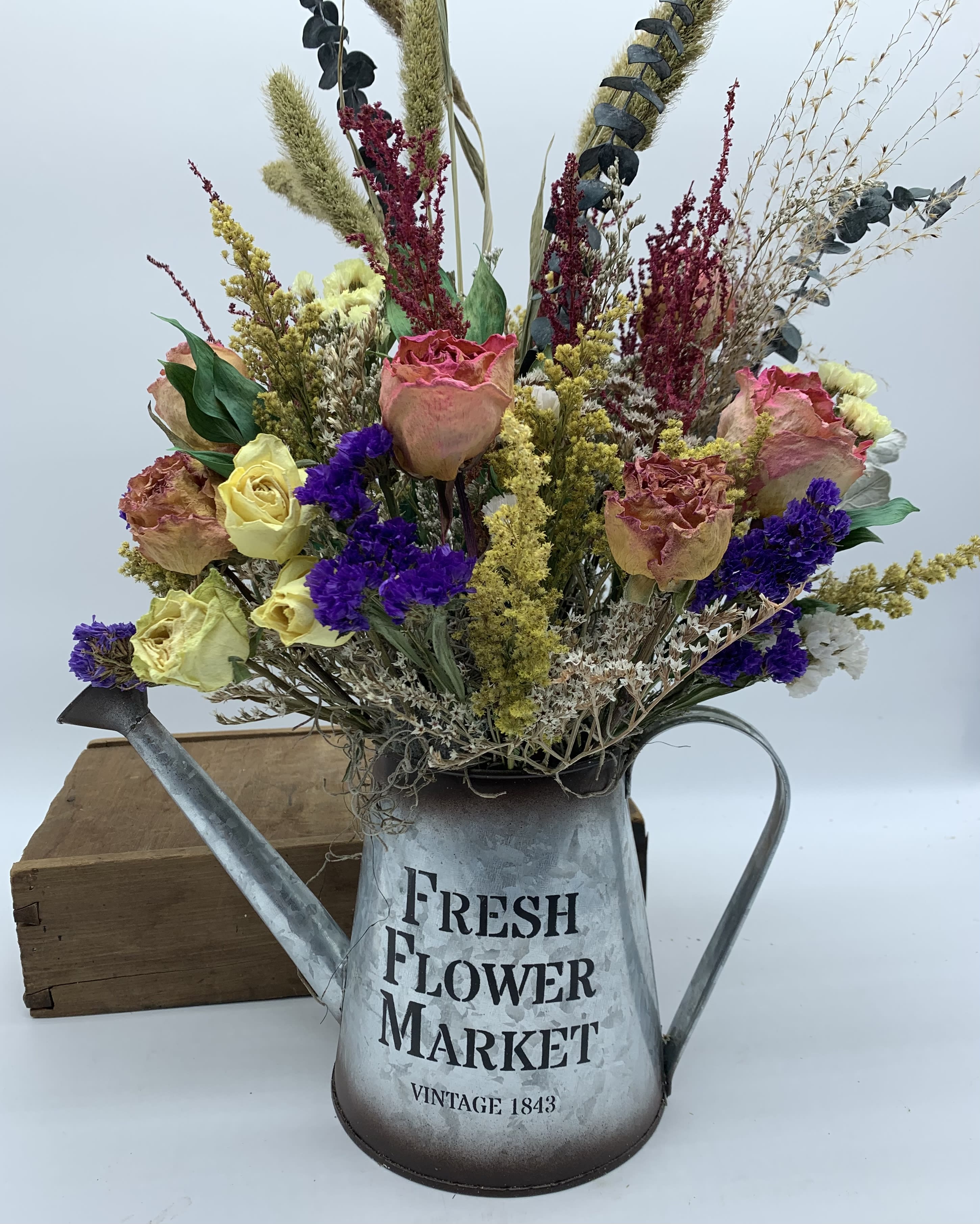 Dried flower arrangement in a metal watering can