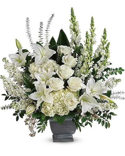 True Horizon Bouquet - "Like the sun on the horizon, this pure white bouquet of hydrangea, roses and lilies offers hope and inspiration. White hydrangea, white roses, white oriental lilies, white snapdragons, and white stock are arranged with huckleberry, seeded eucalyptus, spiral eucalyptus, green ti leaves, and lemon leaf. 
