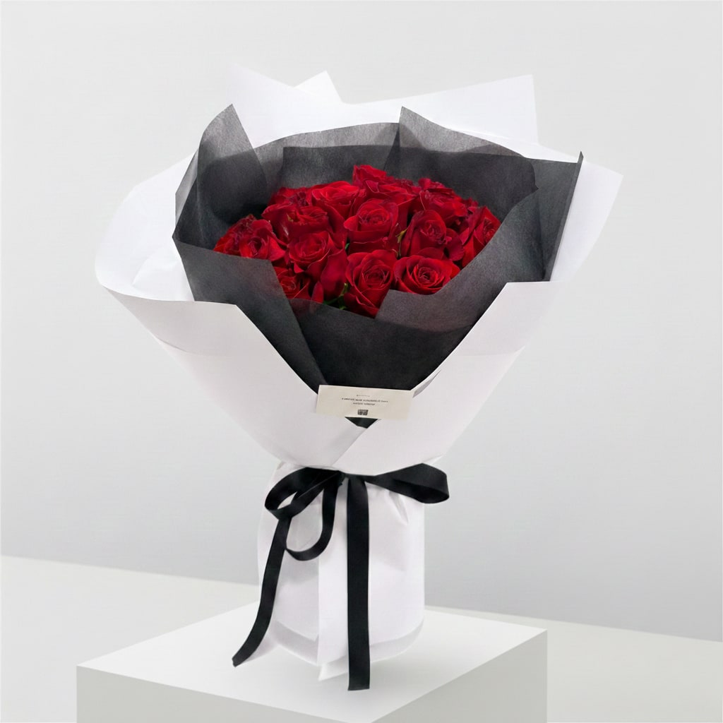 Bouquet of red roses wrapped in black and white paper with a black ribbon