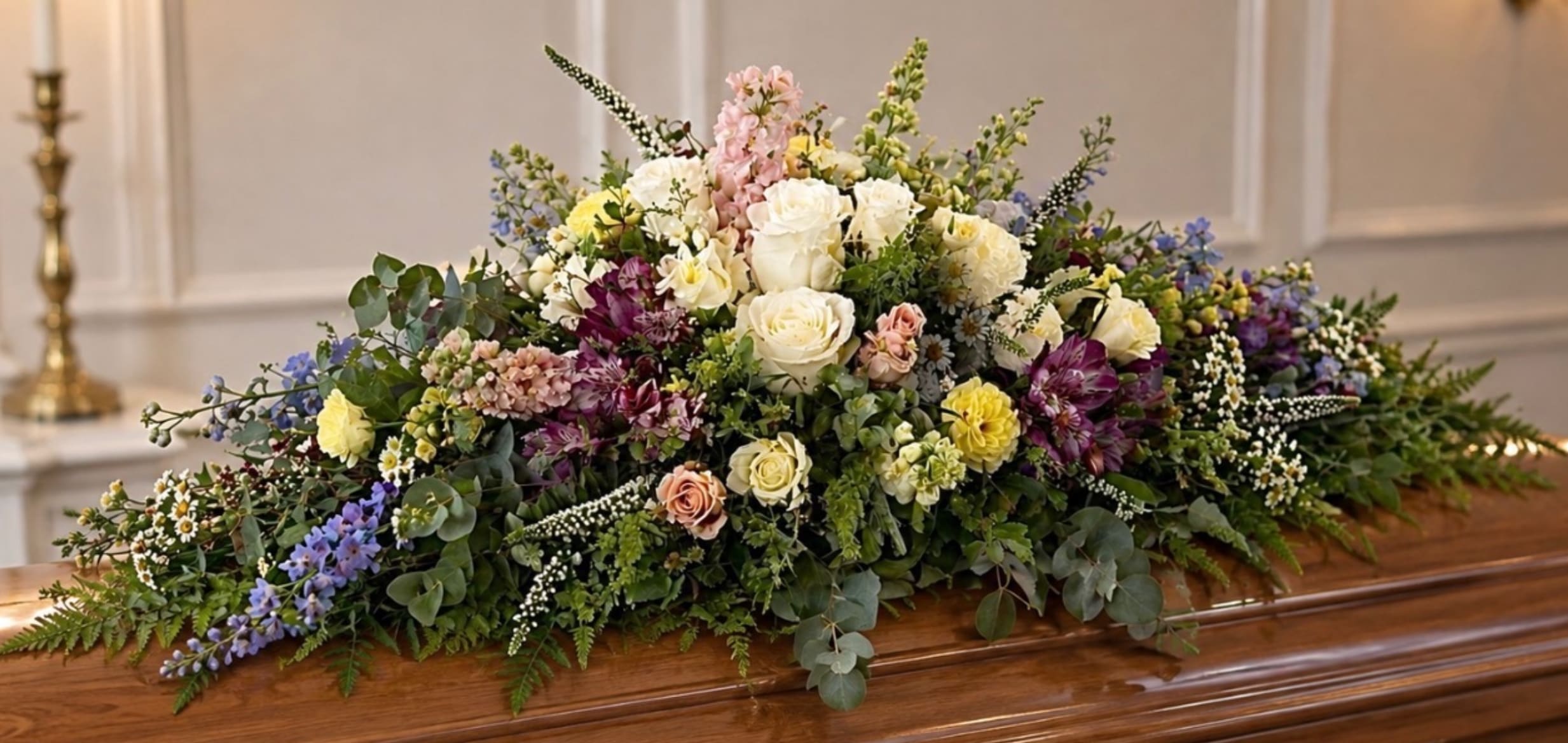 Large casket spray with white, pink, yellow, and purple flowers