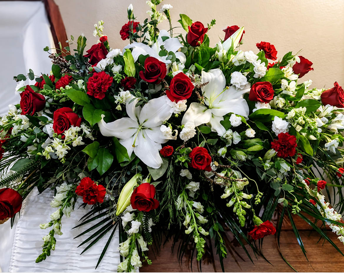 Large red and white floral casket spray with roses and lilies
