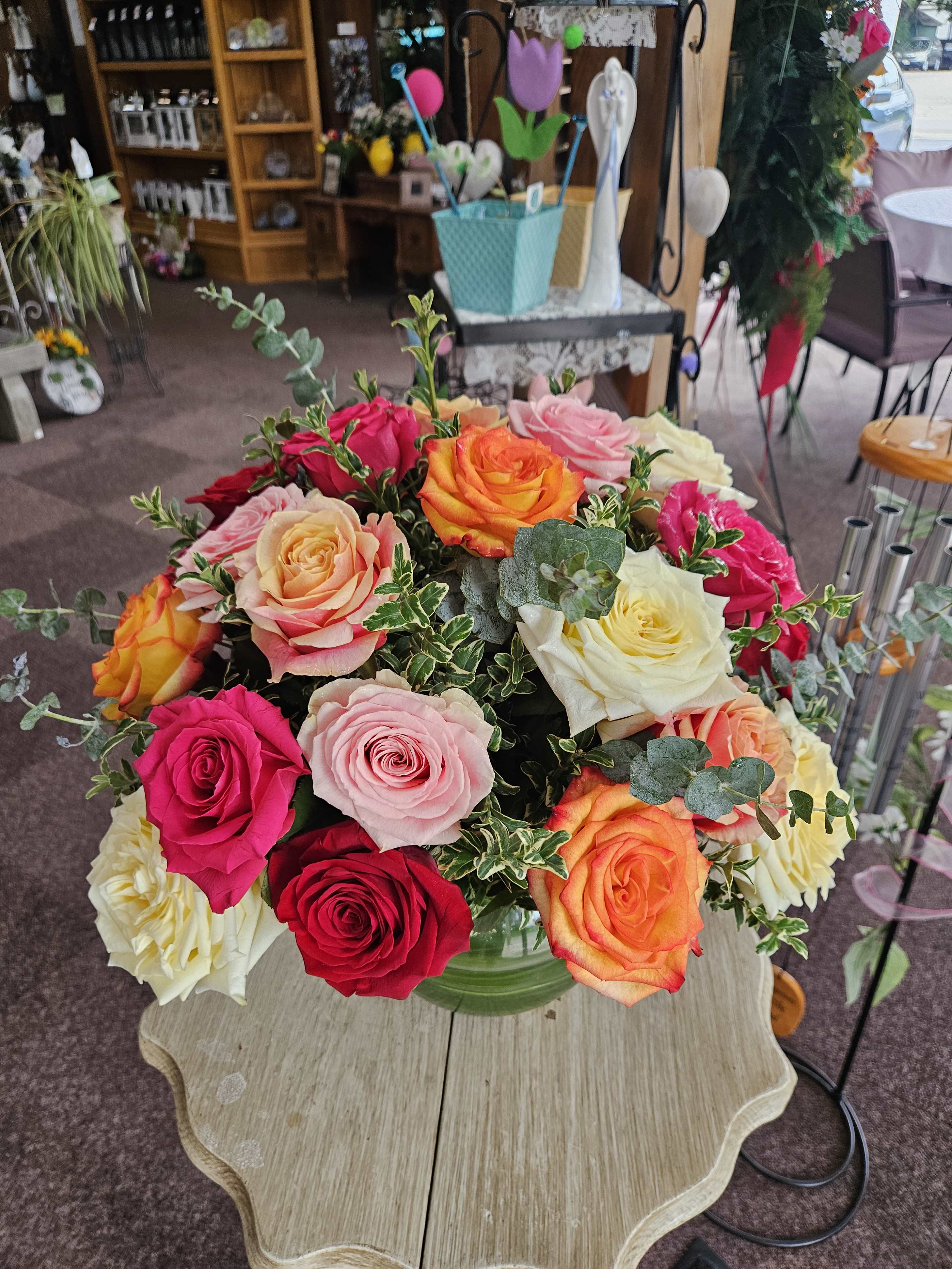 Mixed roses in a glass vase on a table
