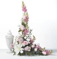 Tall pink and white floral arrangement with a white urn