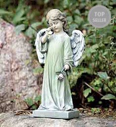 Garden angel statue in a pale green robe holding a small flower