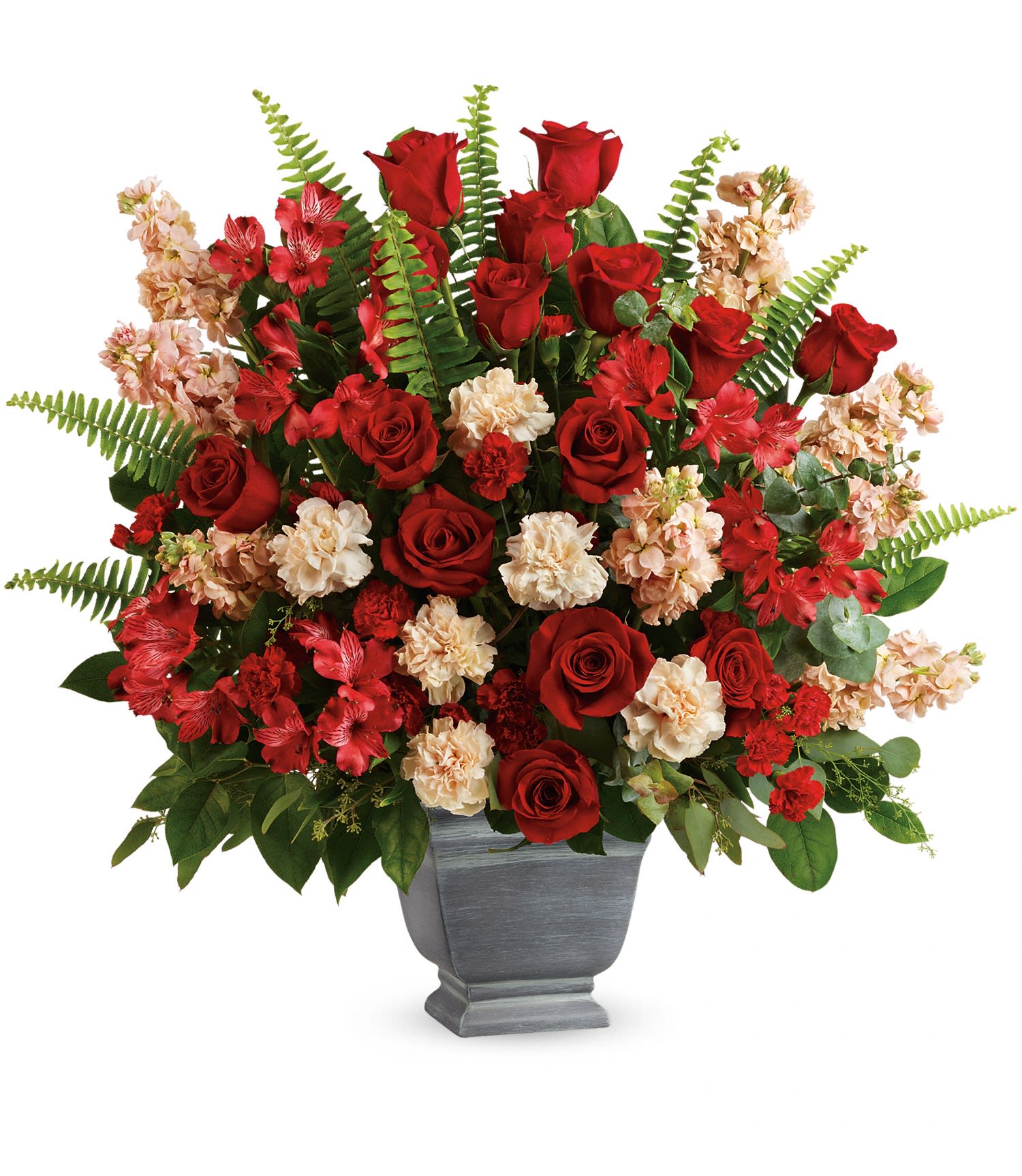 Red roses and peach carnations in a gray urn vase