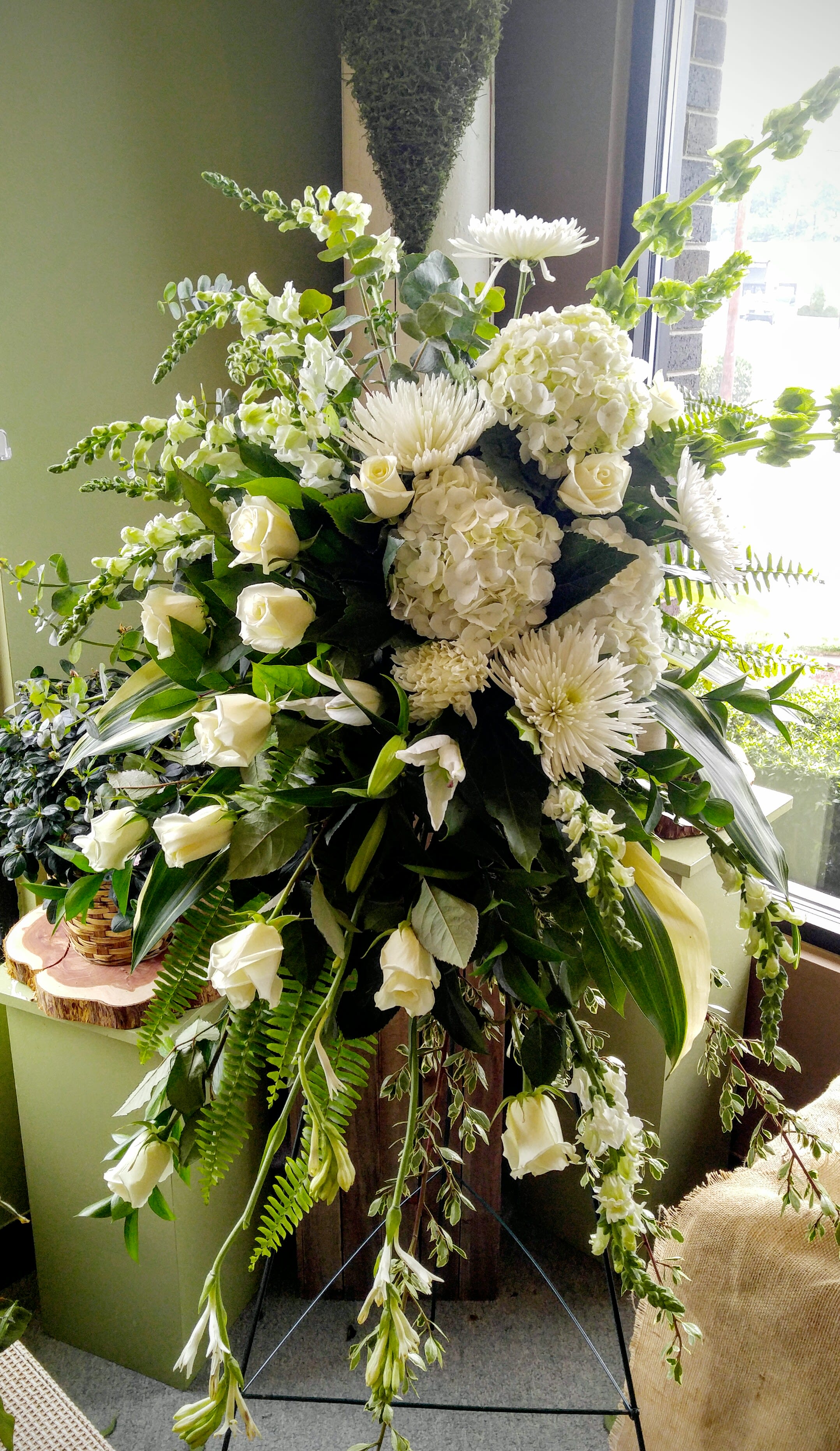 Large white floral standing spray with roses, hydrangeas, and chrysanthemums