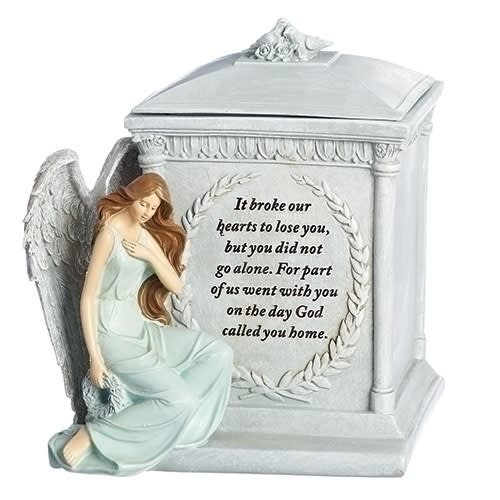 Angel figurine beside a memorial urn with a sympathy message