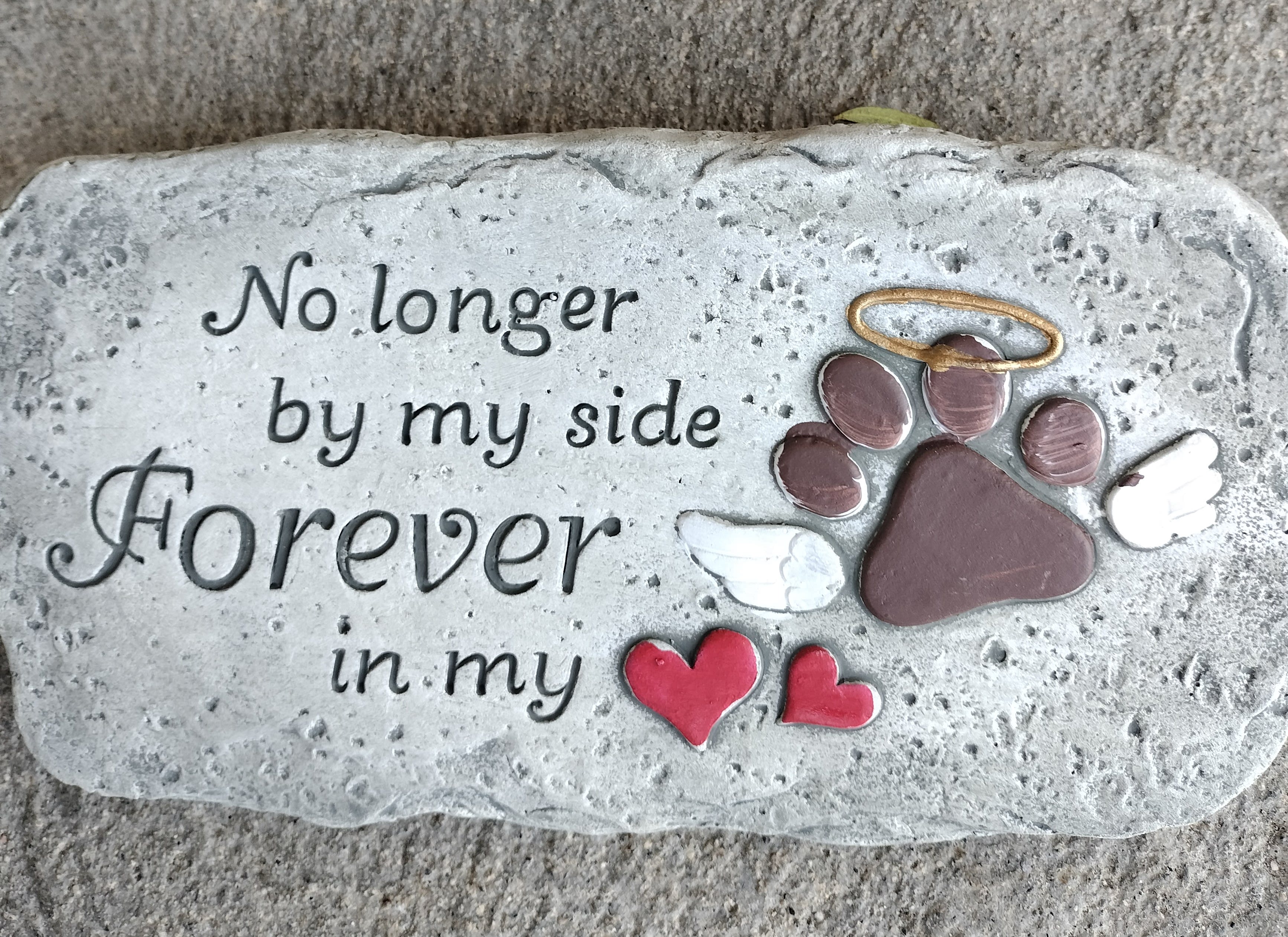 Memorial stone with a paw print, wings, and the words "Forever in my side"