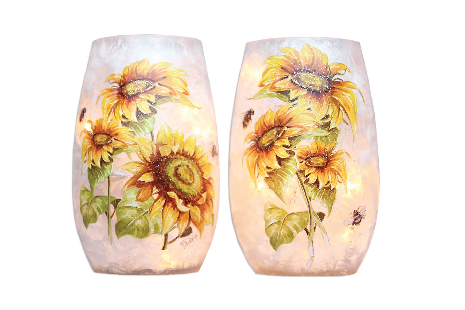 Pair of sunflower-decorated glass candle holders glowing softly