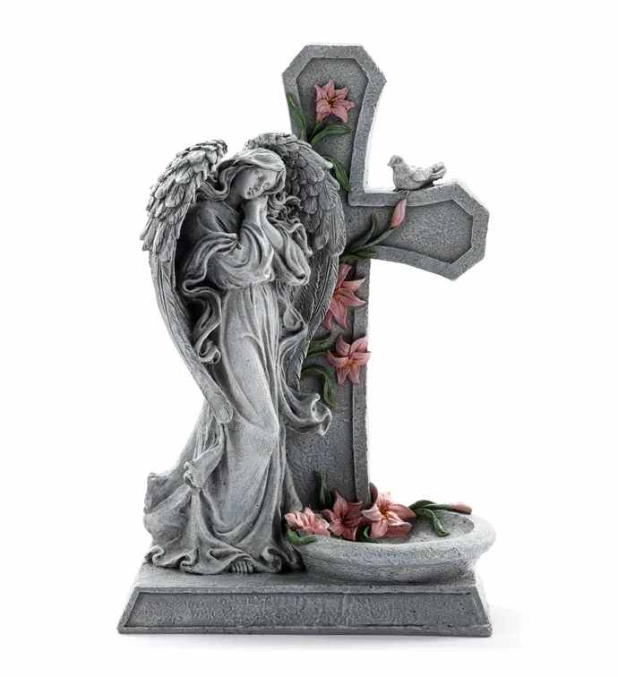 Stone angel statue beside a cross with pink flowers