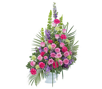 Tall pink and purple floral arrangement in a white vase