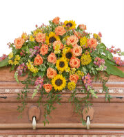 Colorful floral casket spray with sunflowers and peach roses