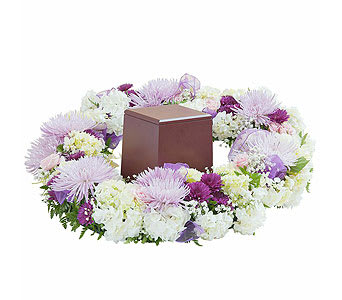 Lavender and white floral wreath around a brown urn
