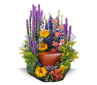 Tall floral arrangement with purple spikes, yellow blooms, and a wooden urn