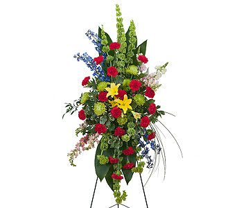 Tall standing floral spray with red, yellow, blue, and green flowers