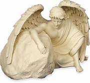 Beige angel figurine with folded wings and a seated figure
