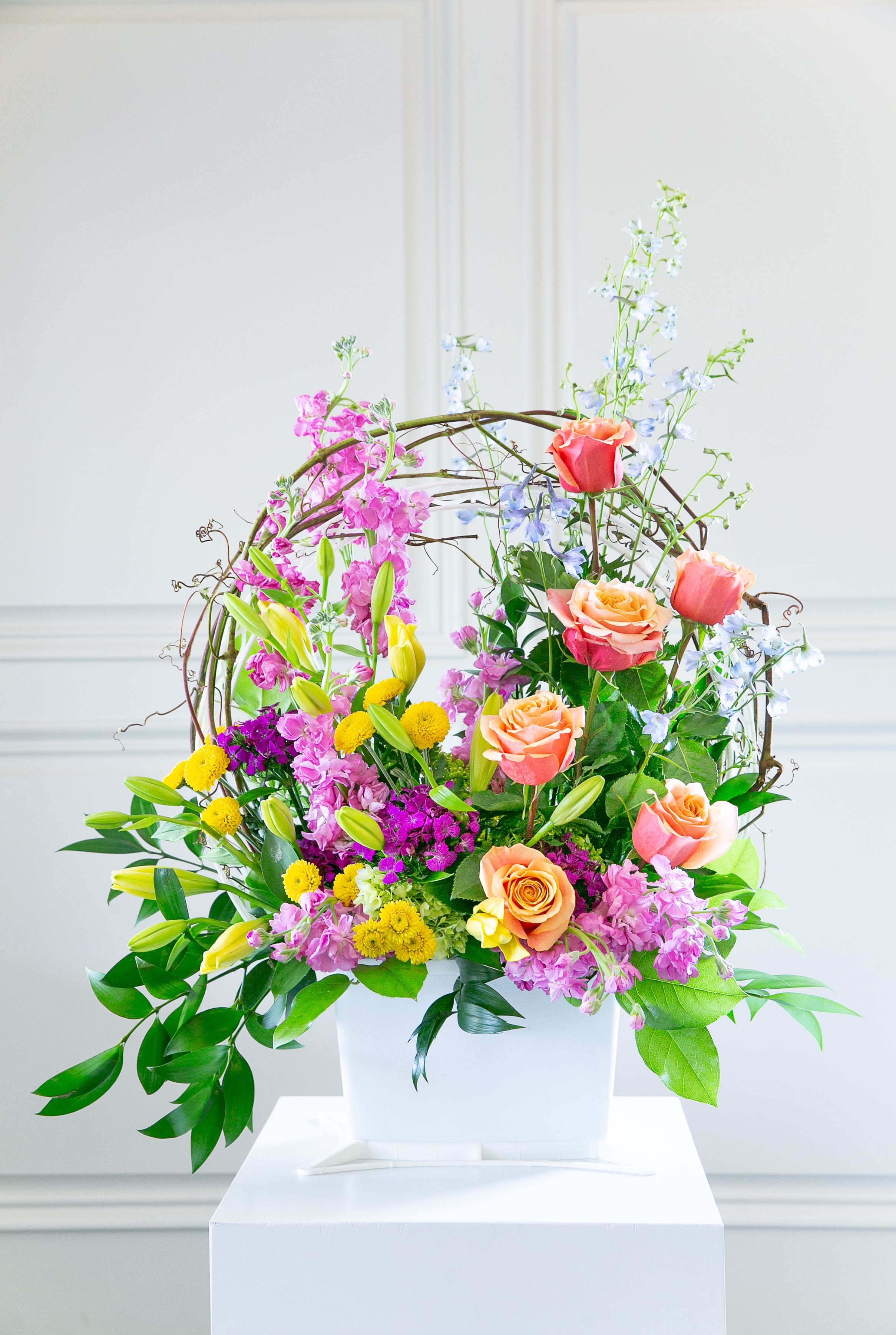 Colorful floral arrangement in a white container with roses and lilies
