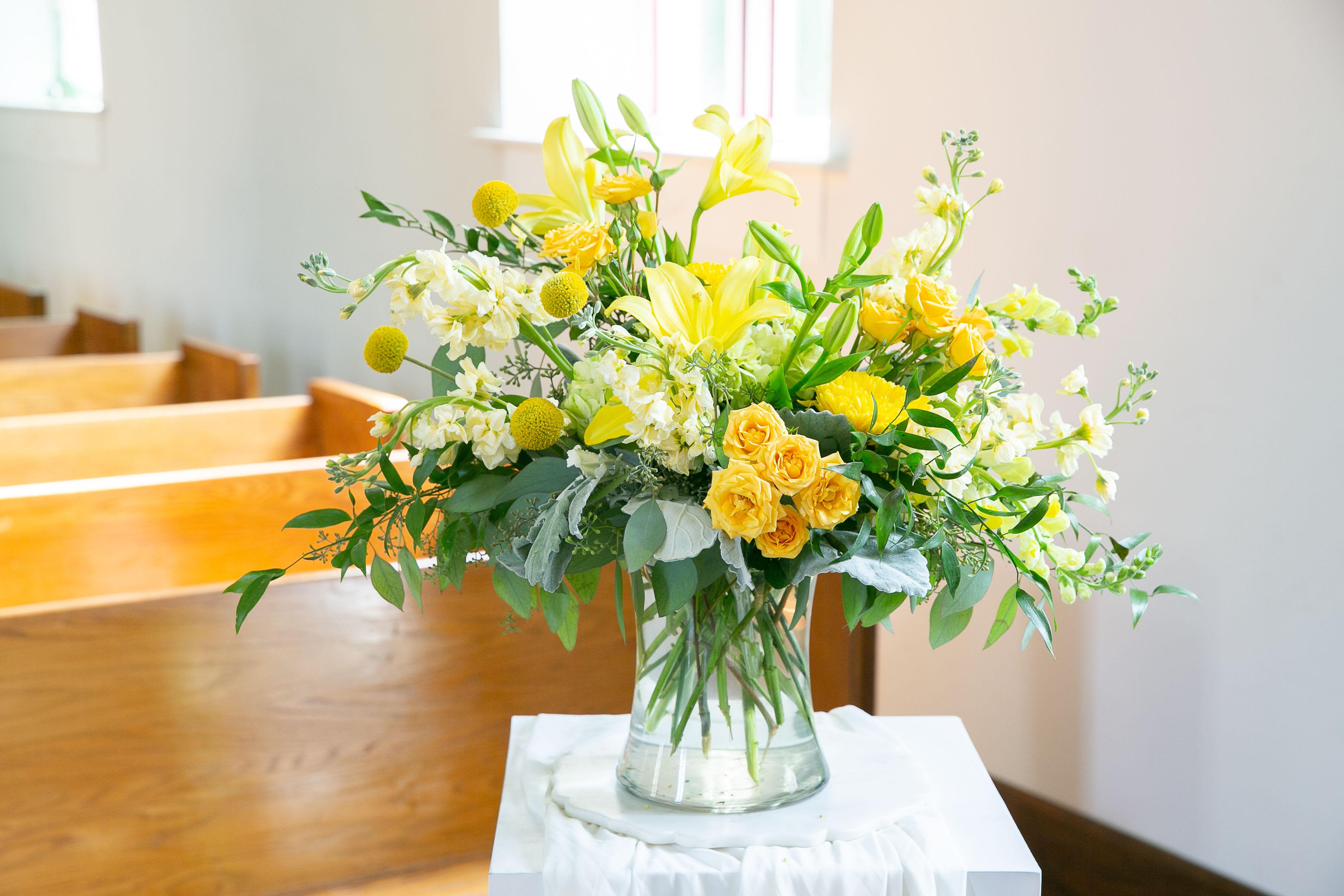 Yellow and white floral arrangement in a clear glass vase