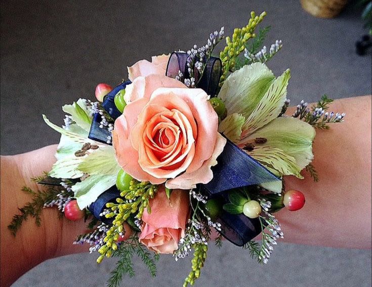 Peach Garden Wristlet - A delicate, garden-style wristlet featuring a soft peach rose as the focal point, accented with airy greenery, subtle berries, and textured blooms. Finished with a sheer ribbon, this piece feels light, romantic, and effortlessly elegant.