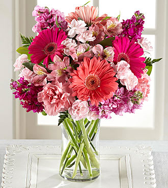 Pink and coral mixed bouquet in a clear glass vase