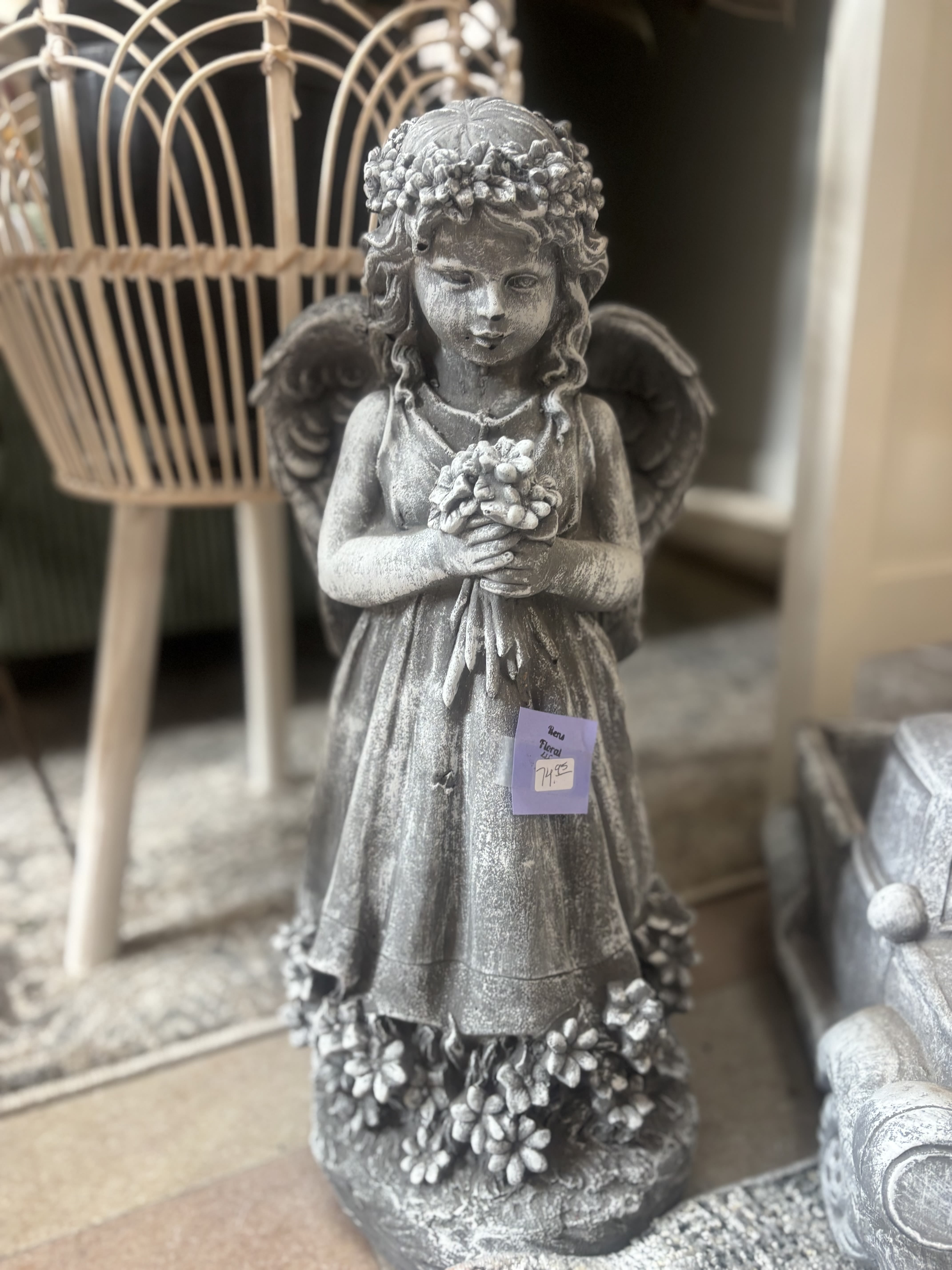 Gray angel statue holding flowers