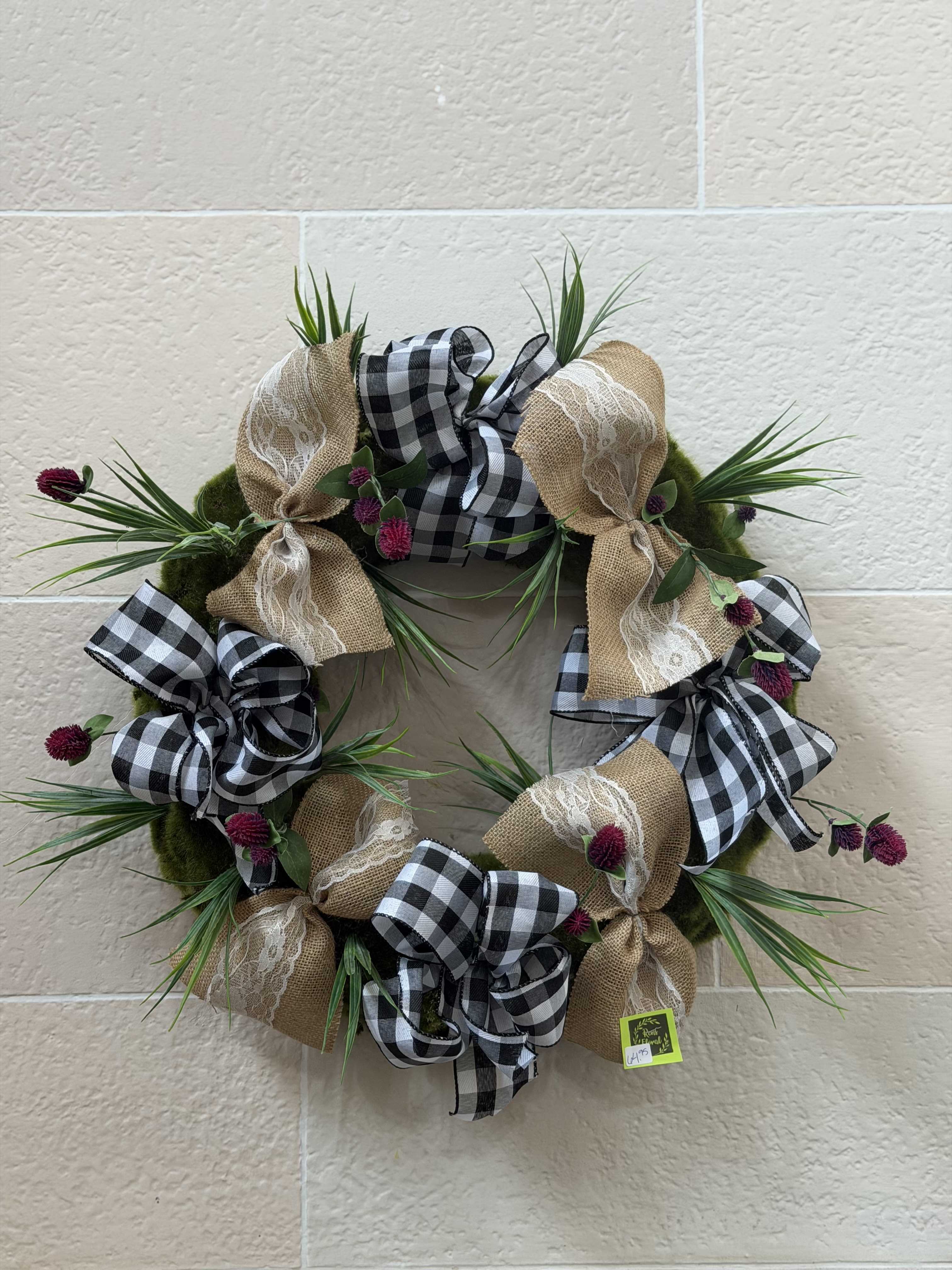 Grass Bow Wreath  - An artificial grass wreath with lined with bows with a few pops of burgundy artificial flowers. 