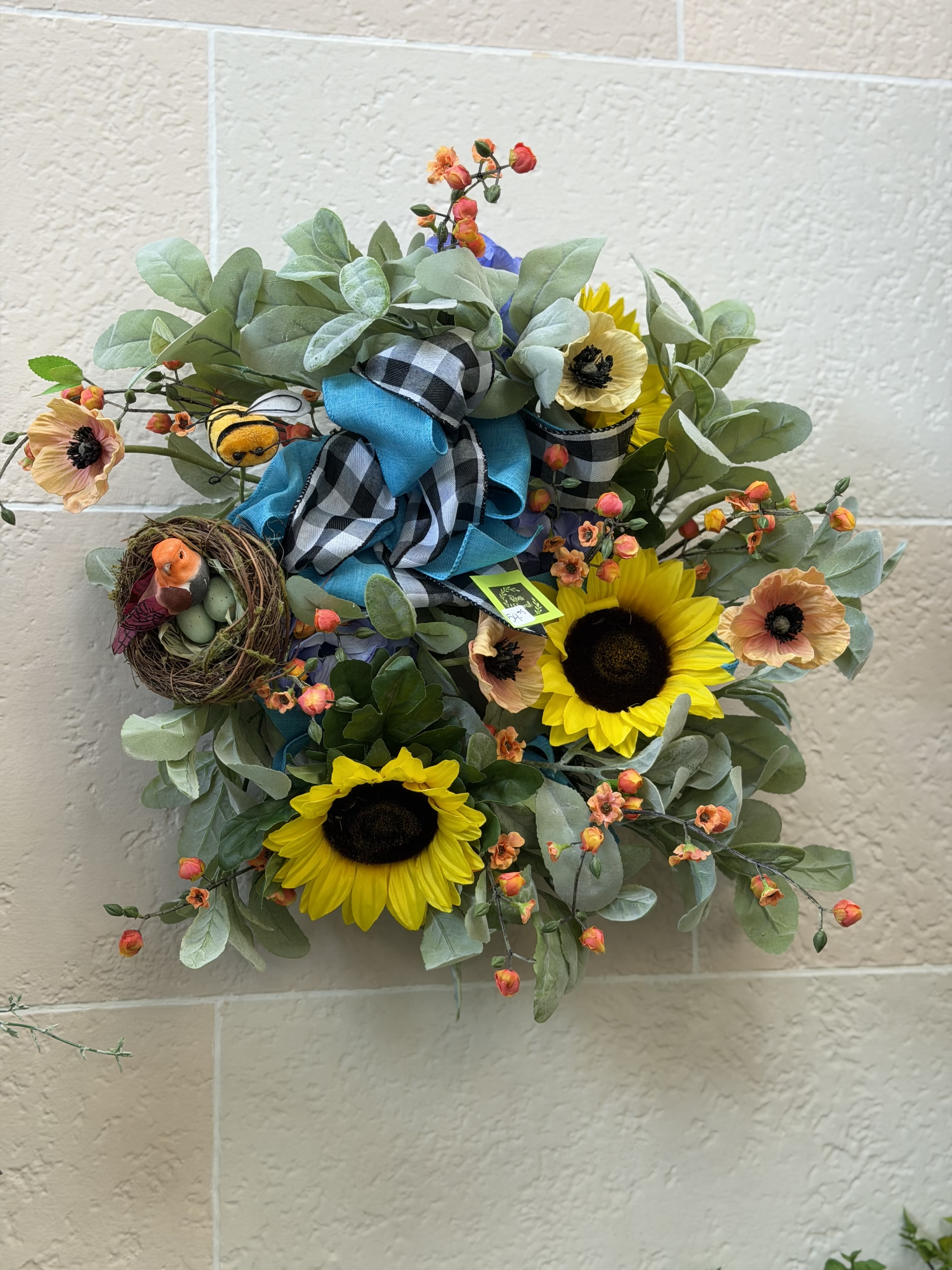 Busy Bee Wreath  - A wreath featuring bright pops of color from artificial blooms and a bird in a nest next to a bee.