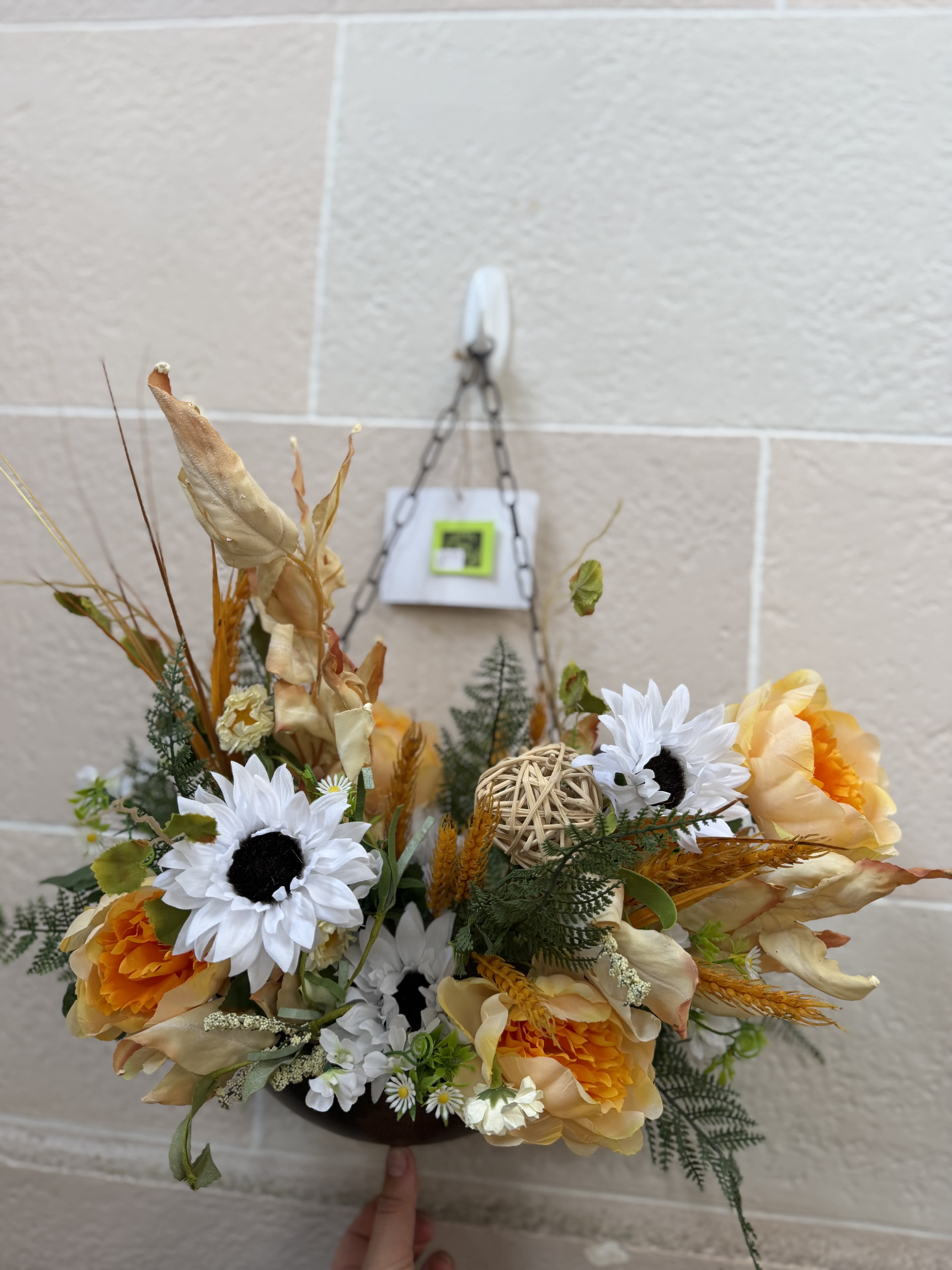 Fall Tin Wall Decor  - A tin wall hanger filled with fall artificial flowers, like sunflowers and wheat. 