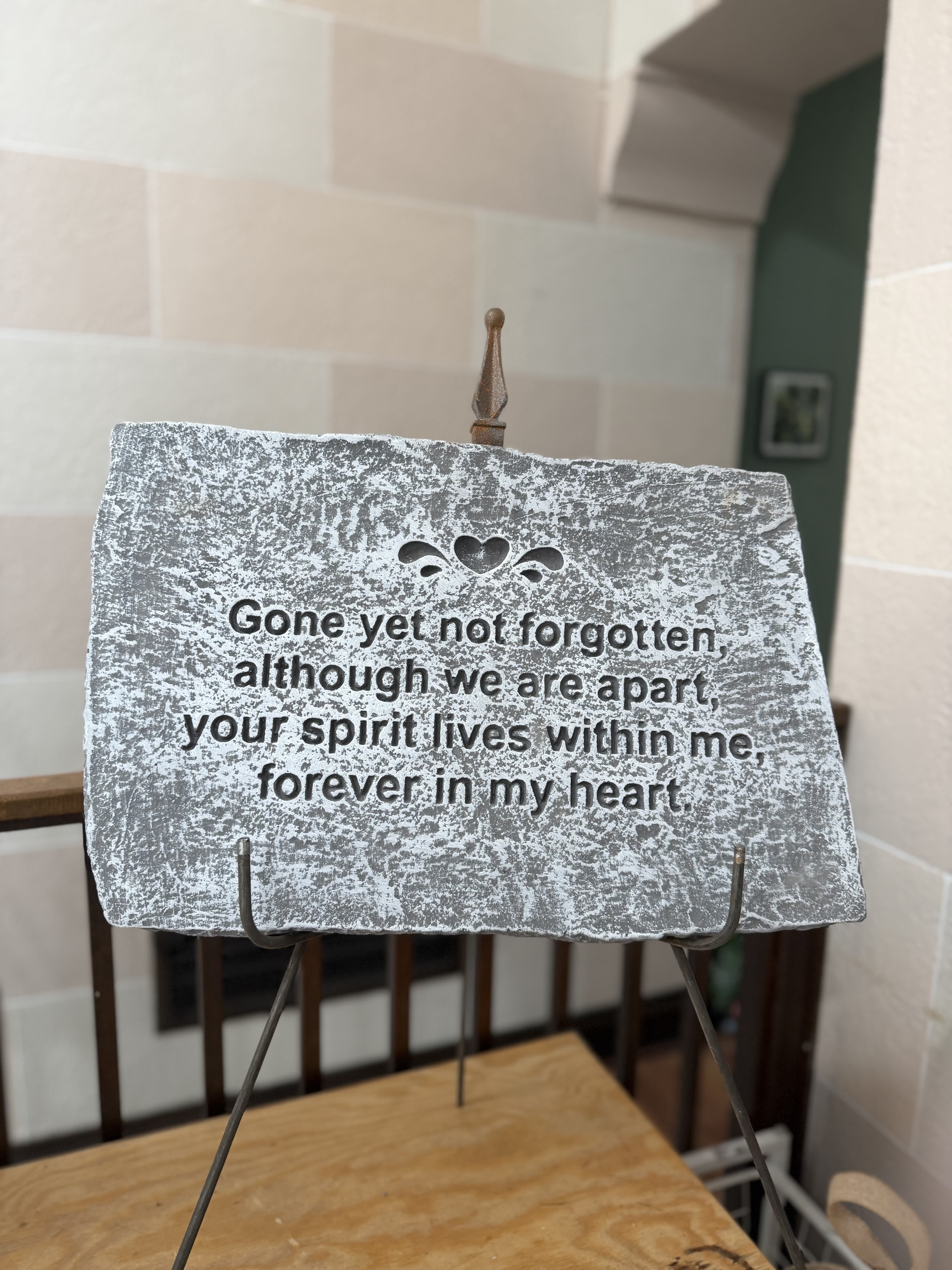 Memorial plaque on a metal stand with an engraved sympathy message