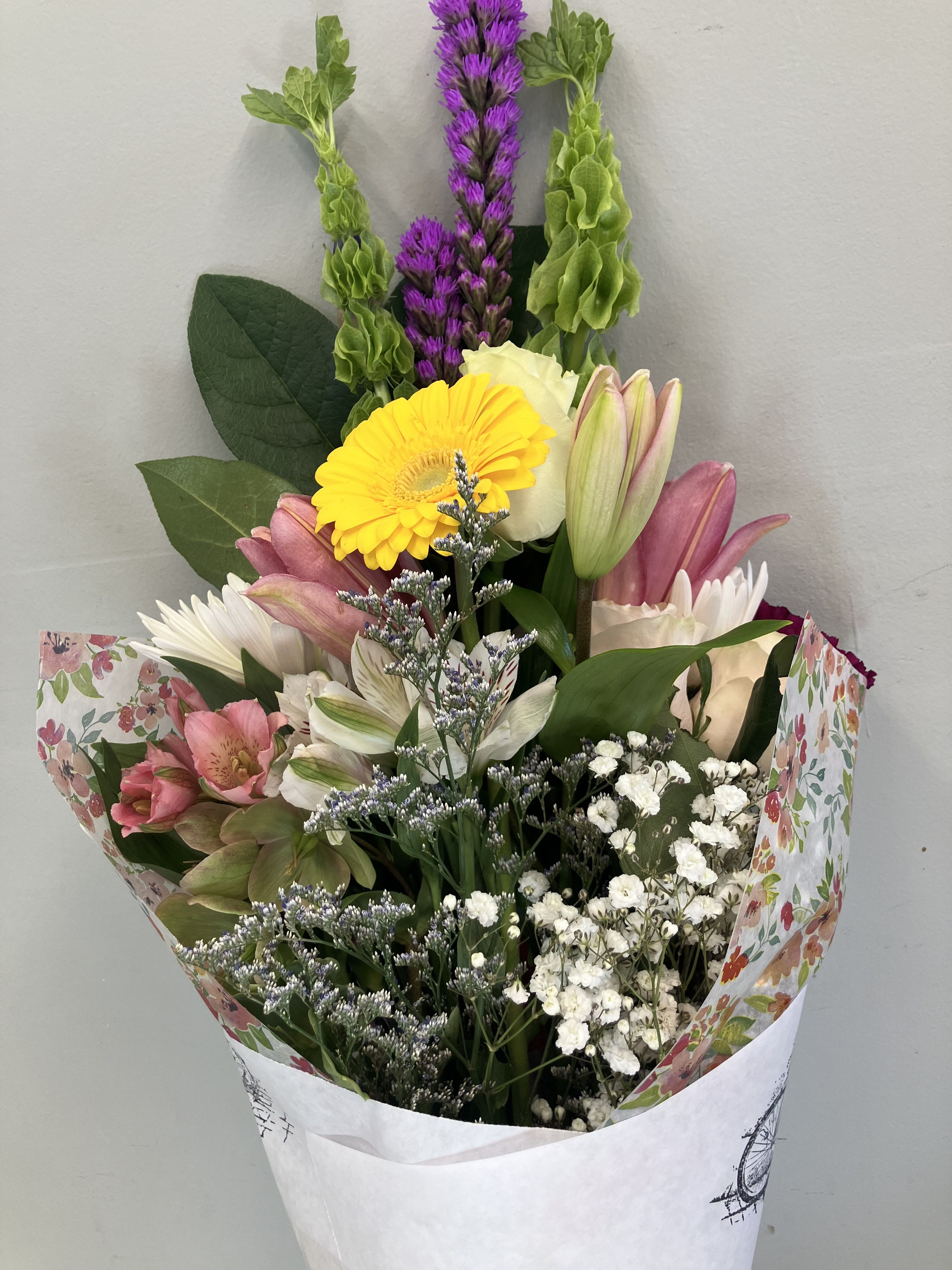 Mixed bouquet with pink lilies, yellow gerbera, and white filler flowers