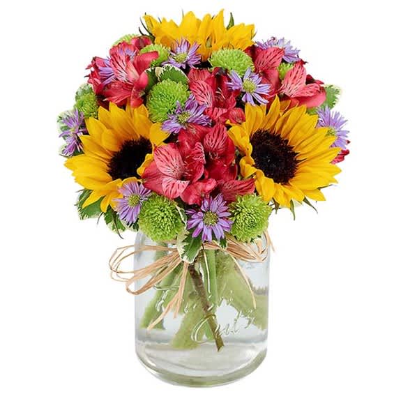 Mixed bouquet with sunflowers, pink alstroemeria, and purple daisies in a glass jar