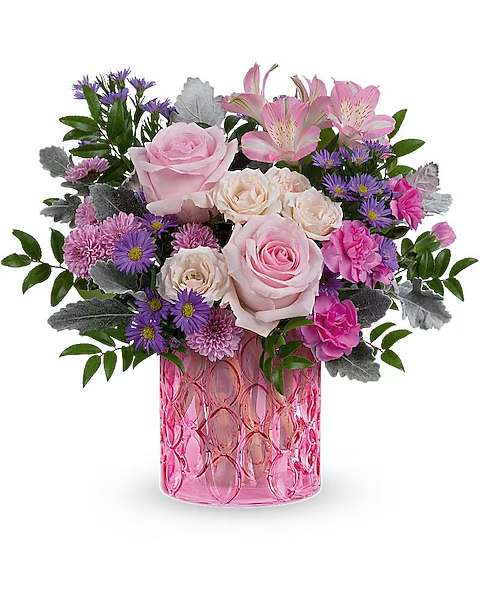 Pink and purple mixed flower arrangement in a pink glass vase