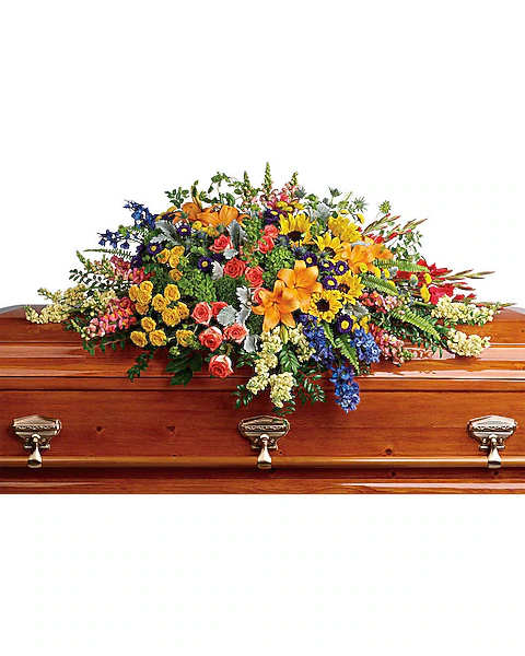 Colorful floral casket spray with orange, yellow, red, and blue flowers
