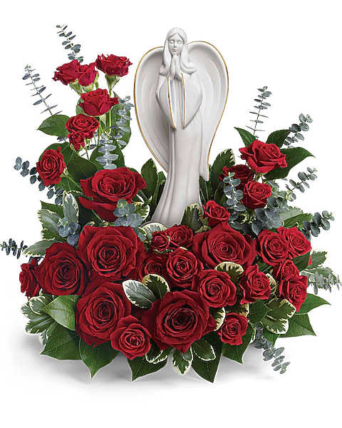 Red roses arranged around a white angel statue