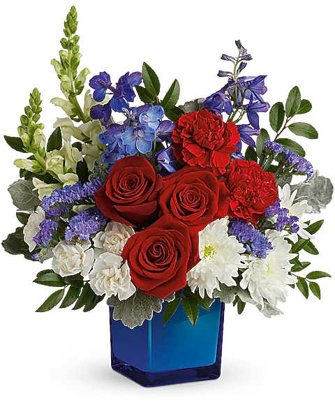 Red roses, white daisies, and purple flowers in a blue vase