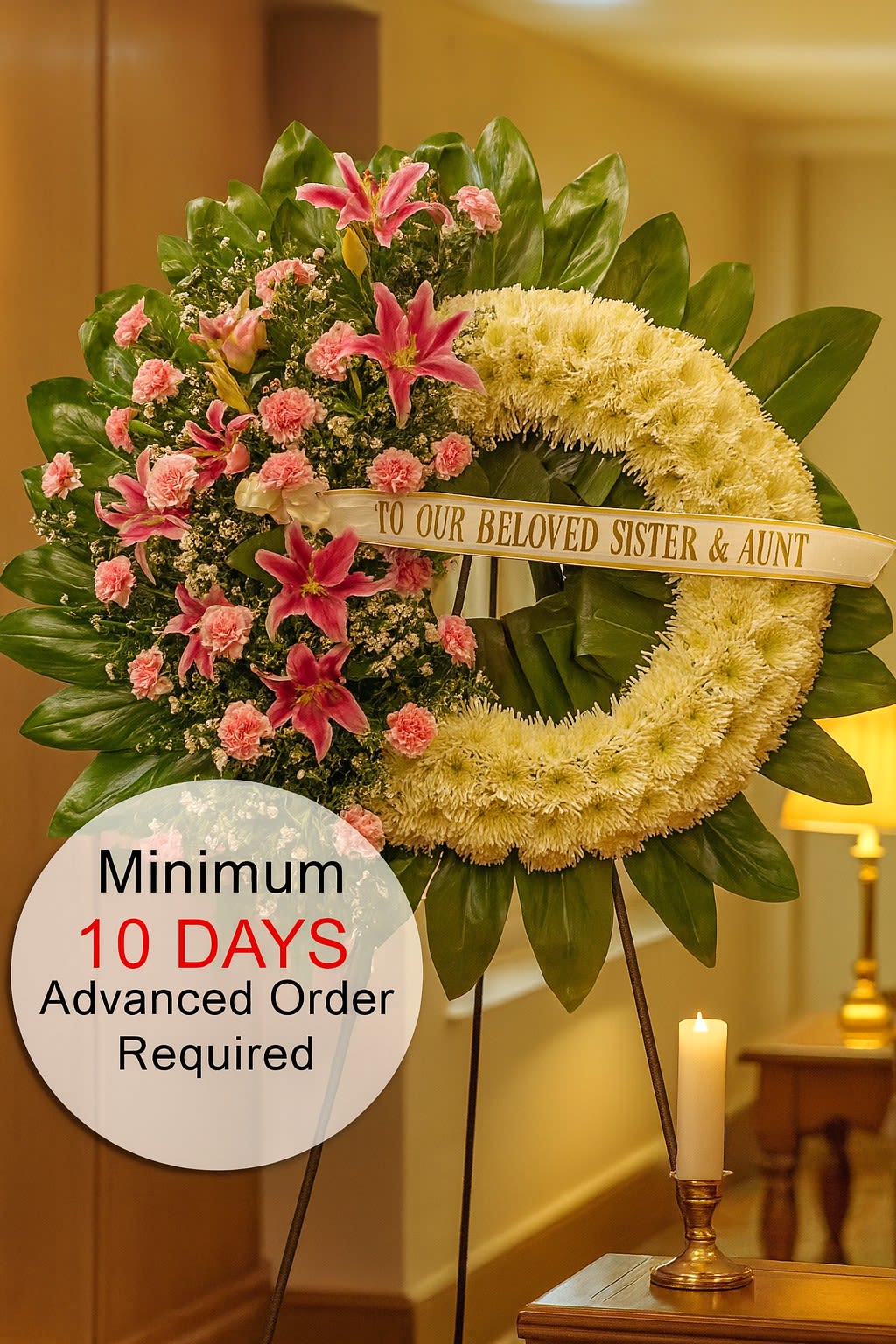 Standing sympathy wreath with white ring and pink lilies and carnations on a tripod stand