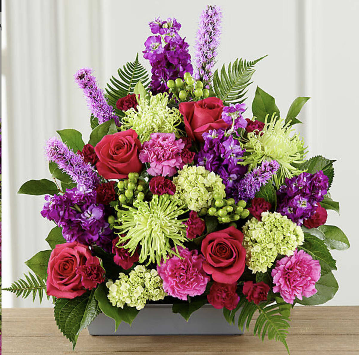 Bright pink and purple floral arrangement in a rectangular vase