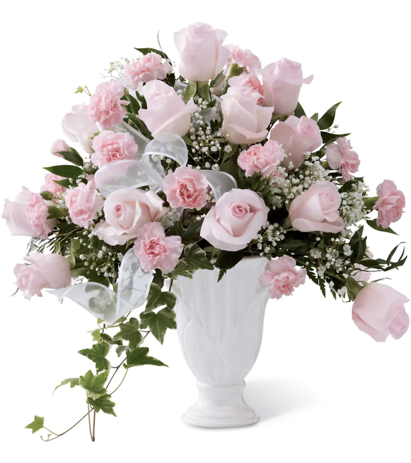 Pink roses and carnations arranged in a white vase with a sheer ribbon