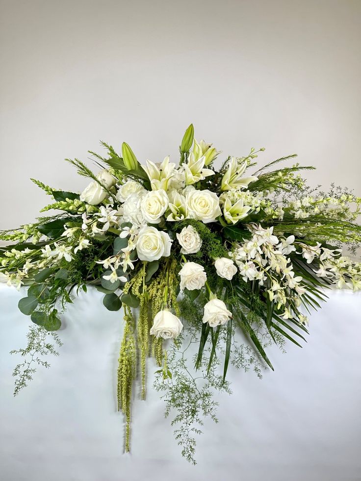 White floral casket spray with roses and lilies