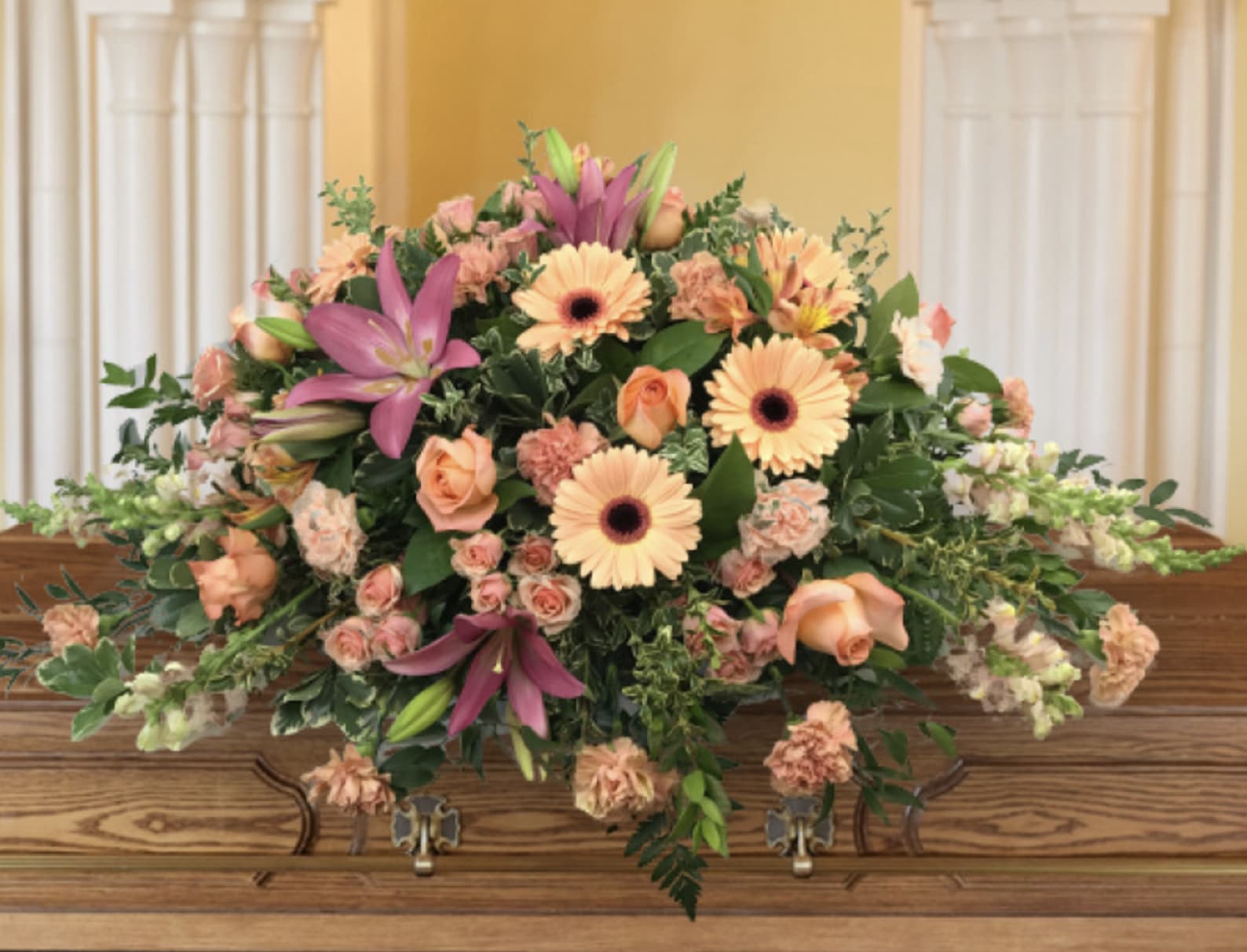Large casket spray with peach and pink flowers