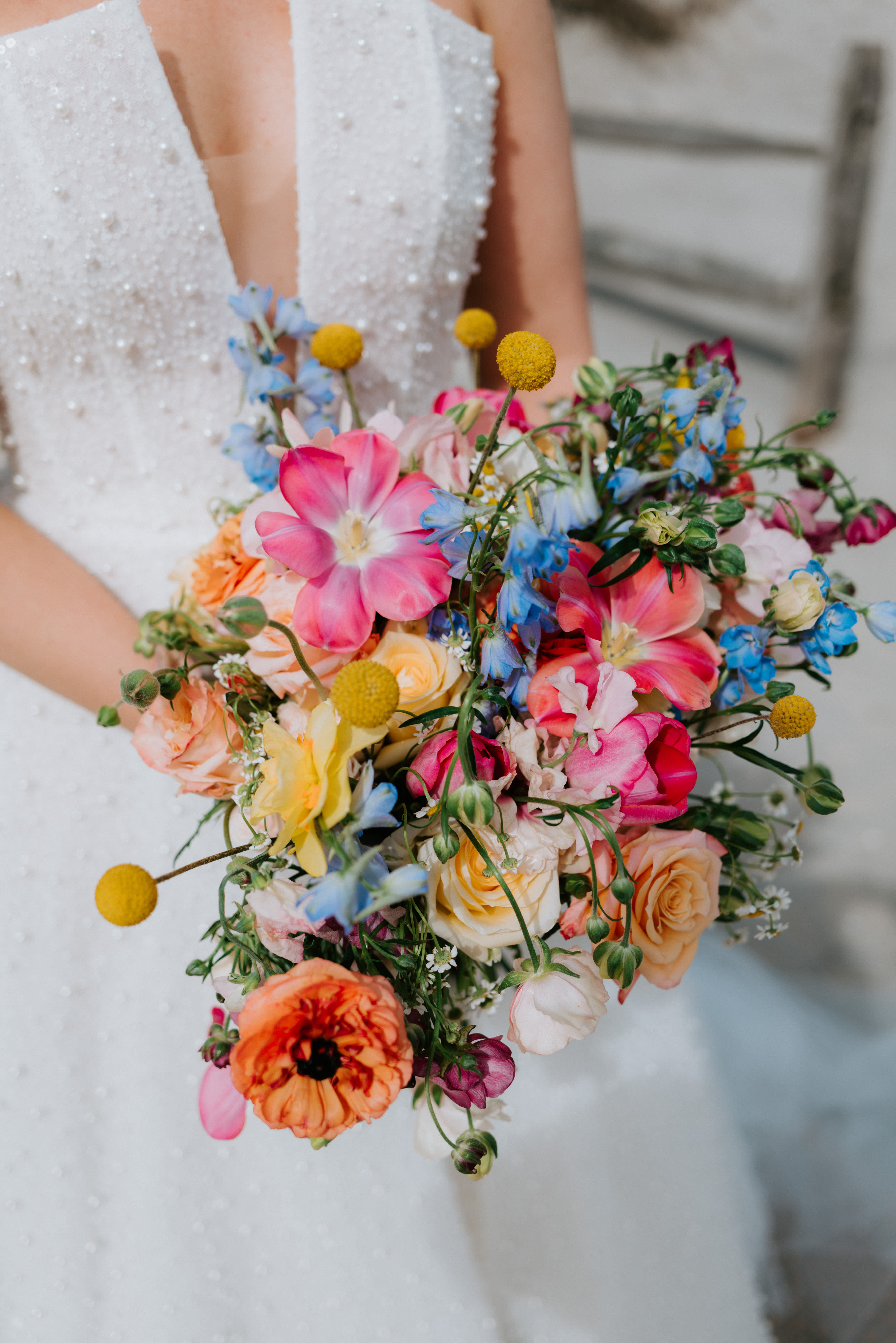 Bride holding a colorful bouquet of roses and mixed blooms