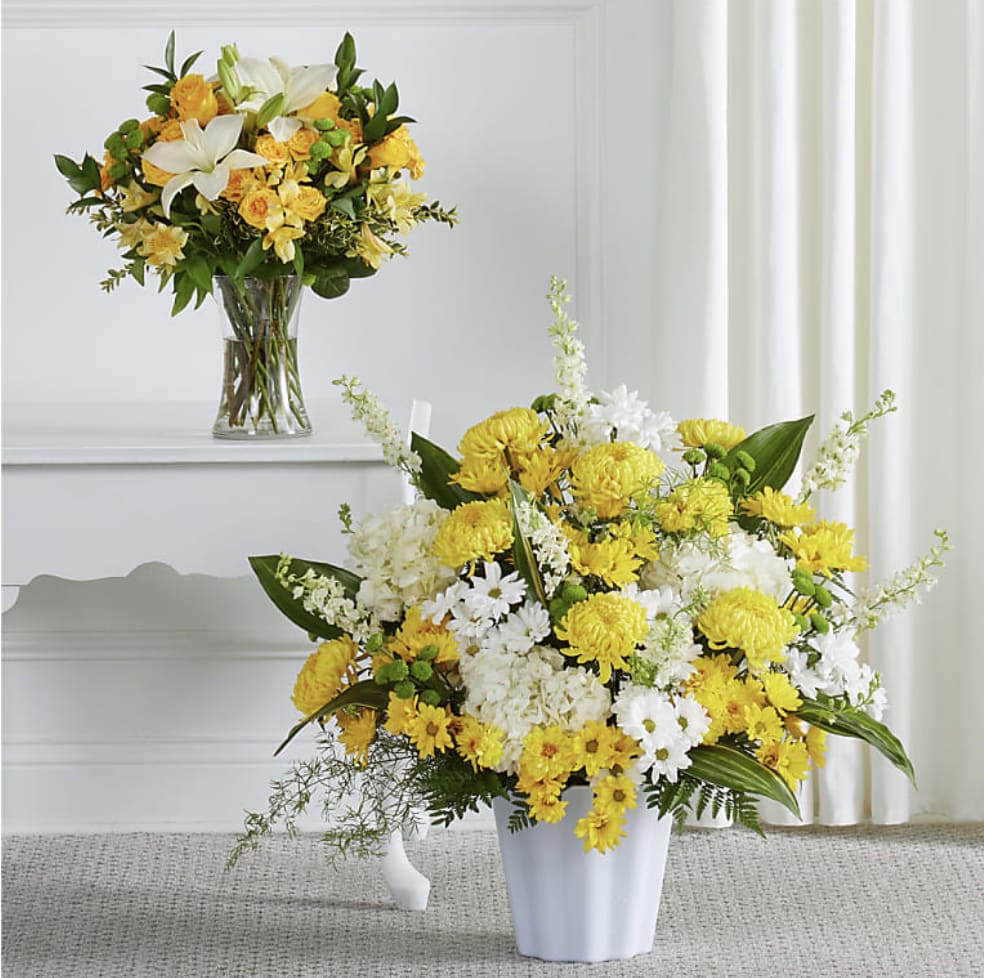 Yellow and white floral arrangements in clear and white vases