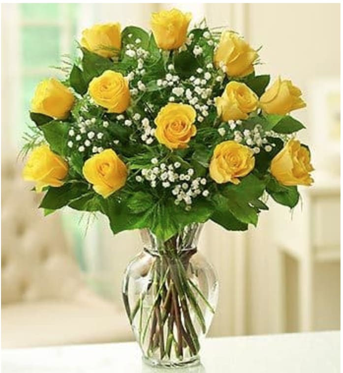 Bouquet of yellow roses with baby's breath in a clear glass vase