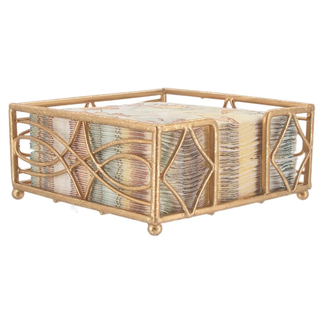 Decorative gold metal napkin holder with a stack of patterned napkins