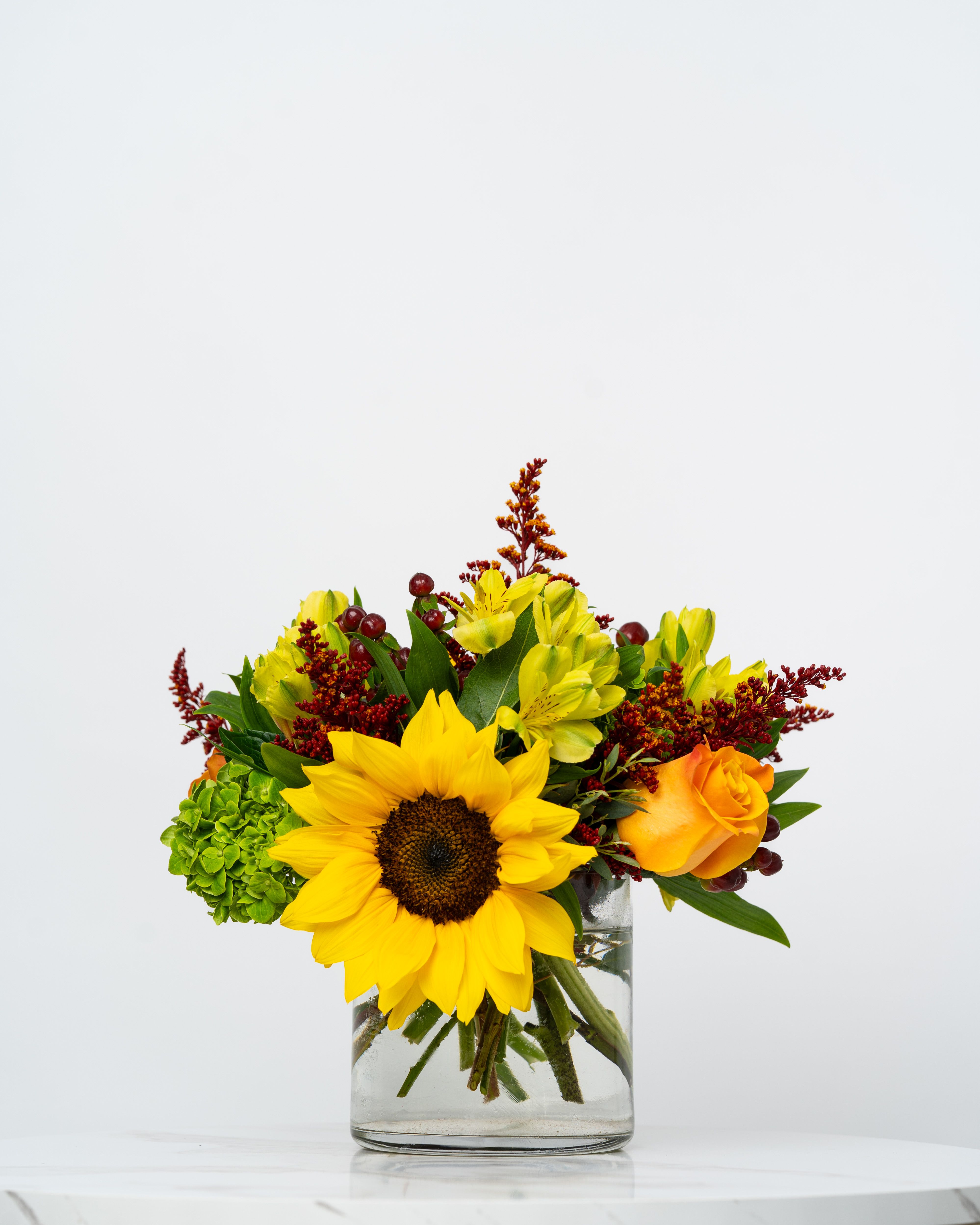 Sunflower and yellow alstroemeria arrangement in a clear glass vase