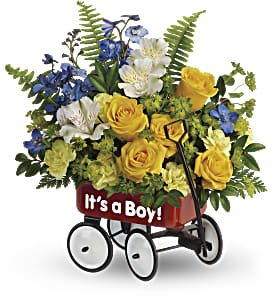 Yellow and blue flower arrangement in a red “It’s a Boy!” toy wagon container