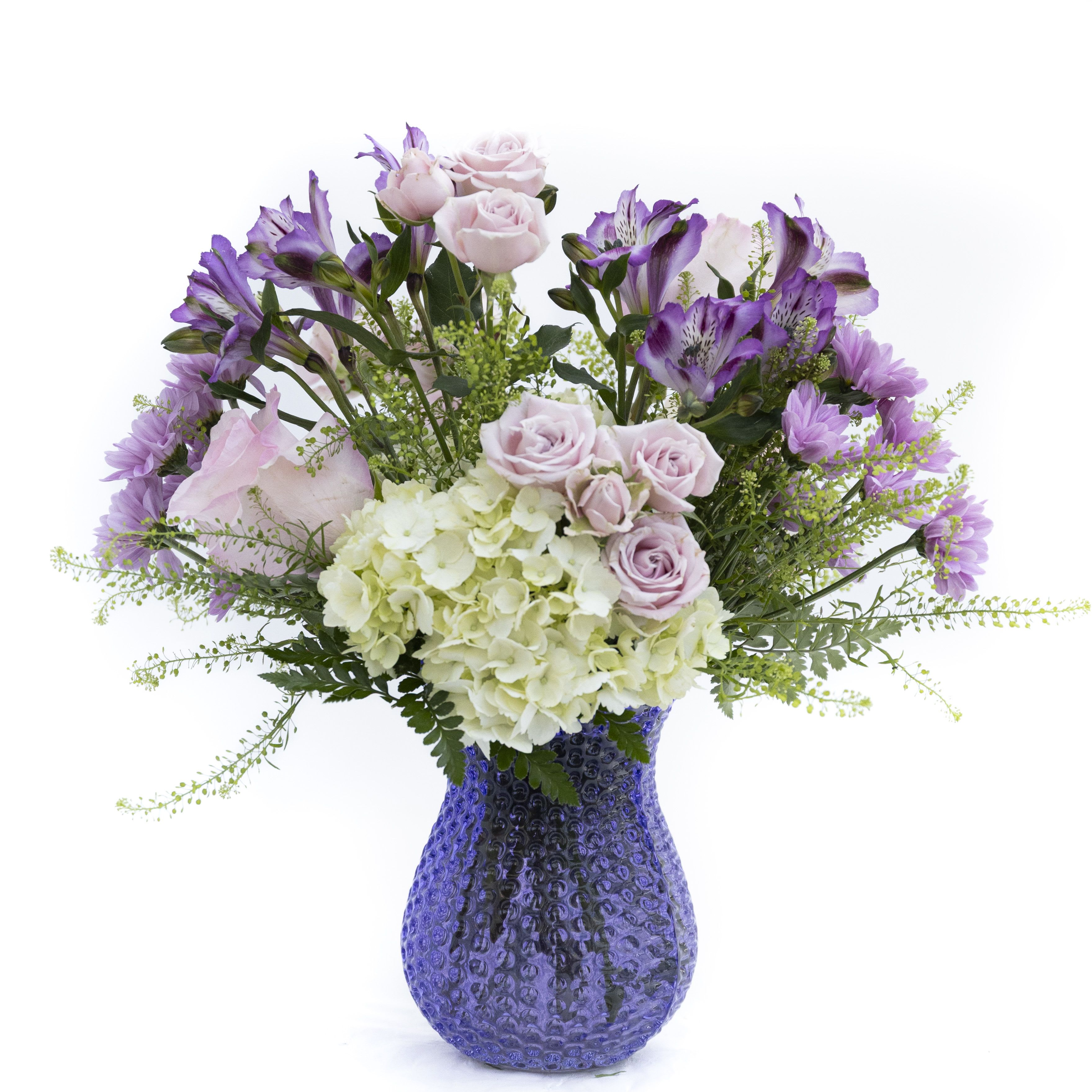 The Emma  - Soft, romantic, and effortlessly elegant, Lavender Whisper captures the beauty of a blooming garden in gentle pastel tones. Featuring delicate blush roses, lush white hydrangea, and vibrant lavender alstroemeria, this arrangement is accented with airy greenery for a natural, flowing look. Designed in a textured violet glass vase, it brings a fresh pop of color while maintaining a serene, graceful feel. Perfect for birthdays, thank-yous, or simply brightening someone’s day, this arrangement offers a calming charm that feels both timeless and thoughtfully curated. Delivery to Syracuse, North Syracuse, East Syracuse, Dewitt, Manlius, Jamesville, Fayetteville, Camillus, Marcellus, Minoa, Mattydale, Liverpool, Kirkville