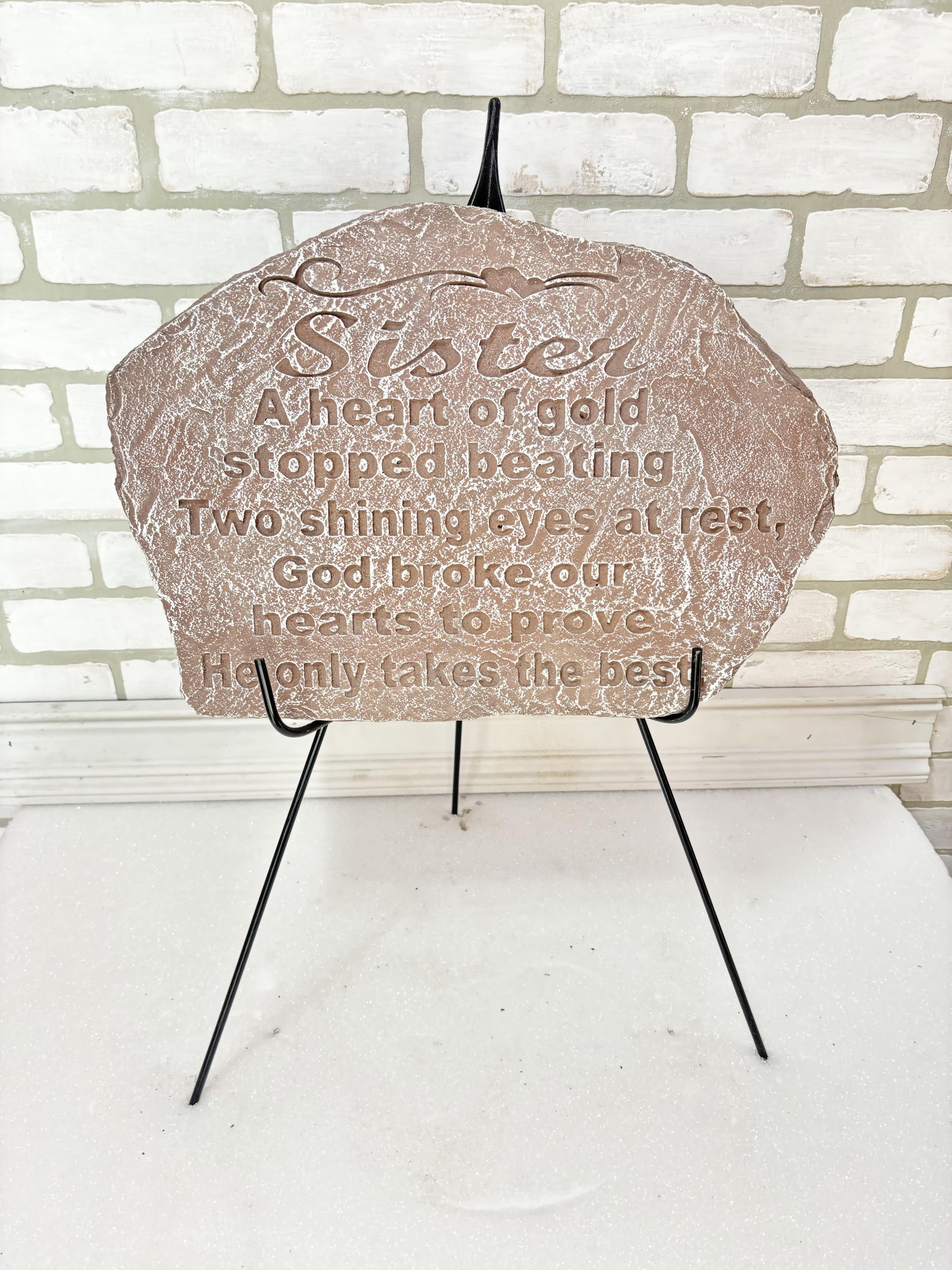 Decorative memorial plaque on a black stand with engraved text
